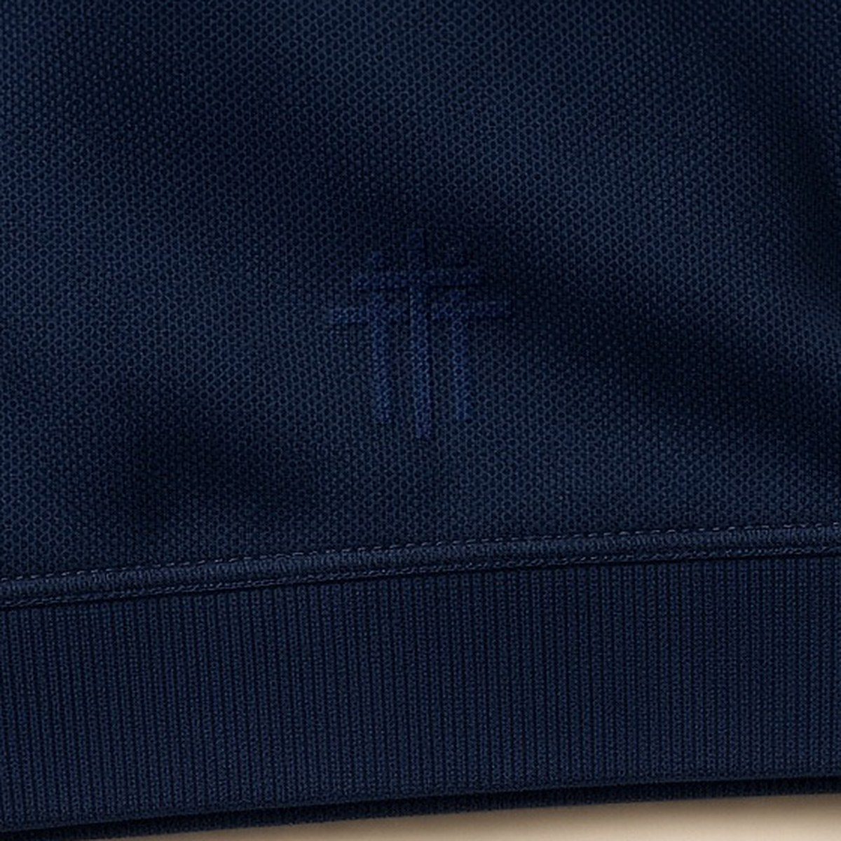 Tone-on-tone mark on a navy sleeve